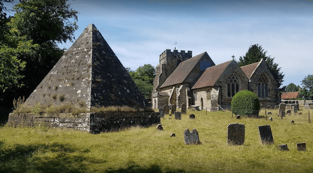 A pyramid structure in the middle of a church yard.